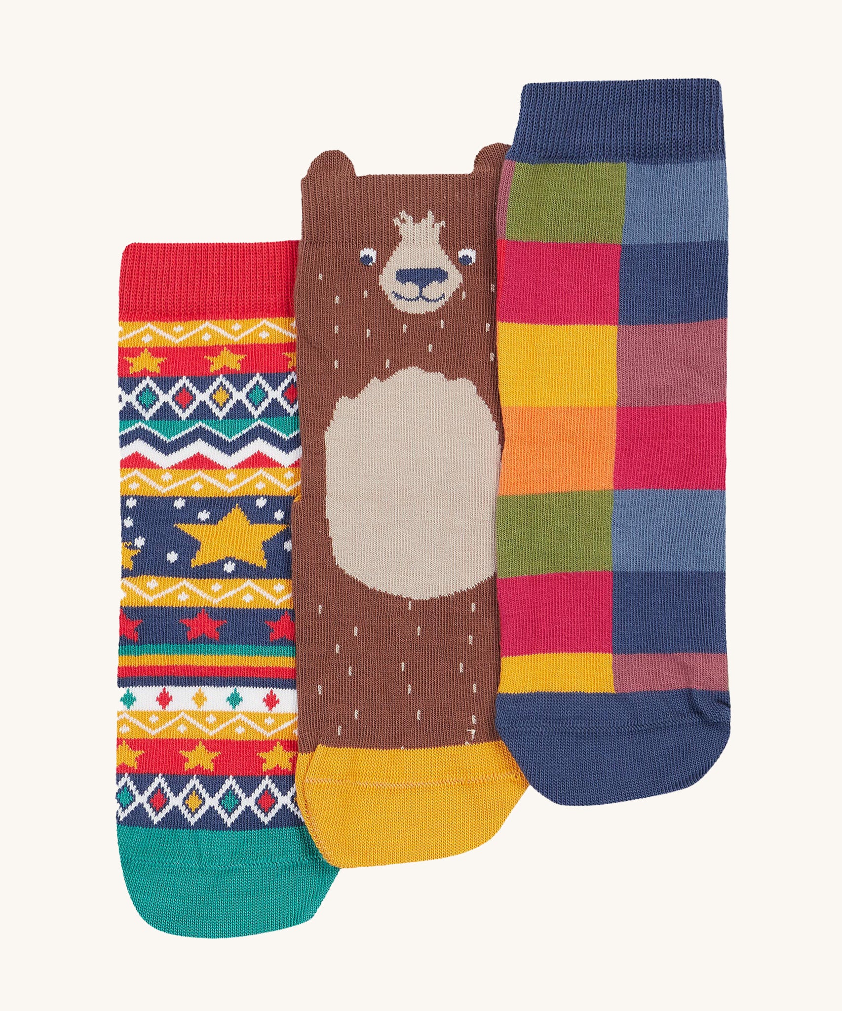 Frugi Rock My Socks - Bear 3 Pack. 3 pairs of organic cotton socks, in a festive print. From left to right is a festive star design with multiple colours and shapes, the middle is a cute bear with little ears on the ankle cuff, and the right is a block colour print sock