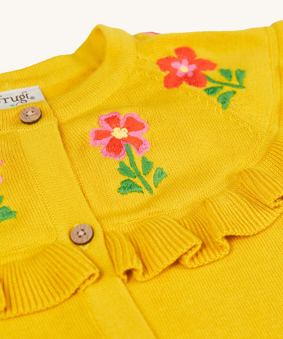 A closer look at the embroidered flowers and ruffled collar on the Frugi Romi Ruffle Cardigan - Dandelion/Flowers