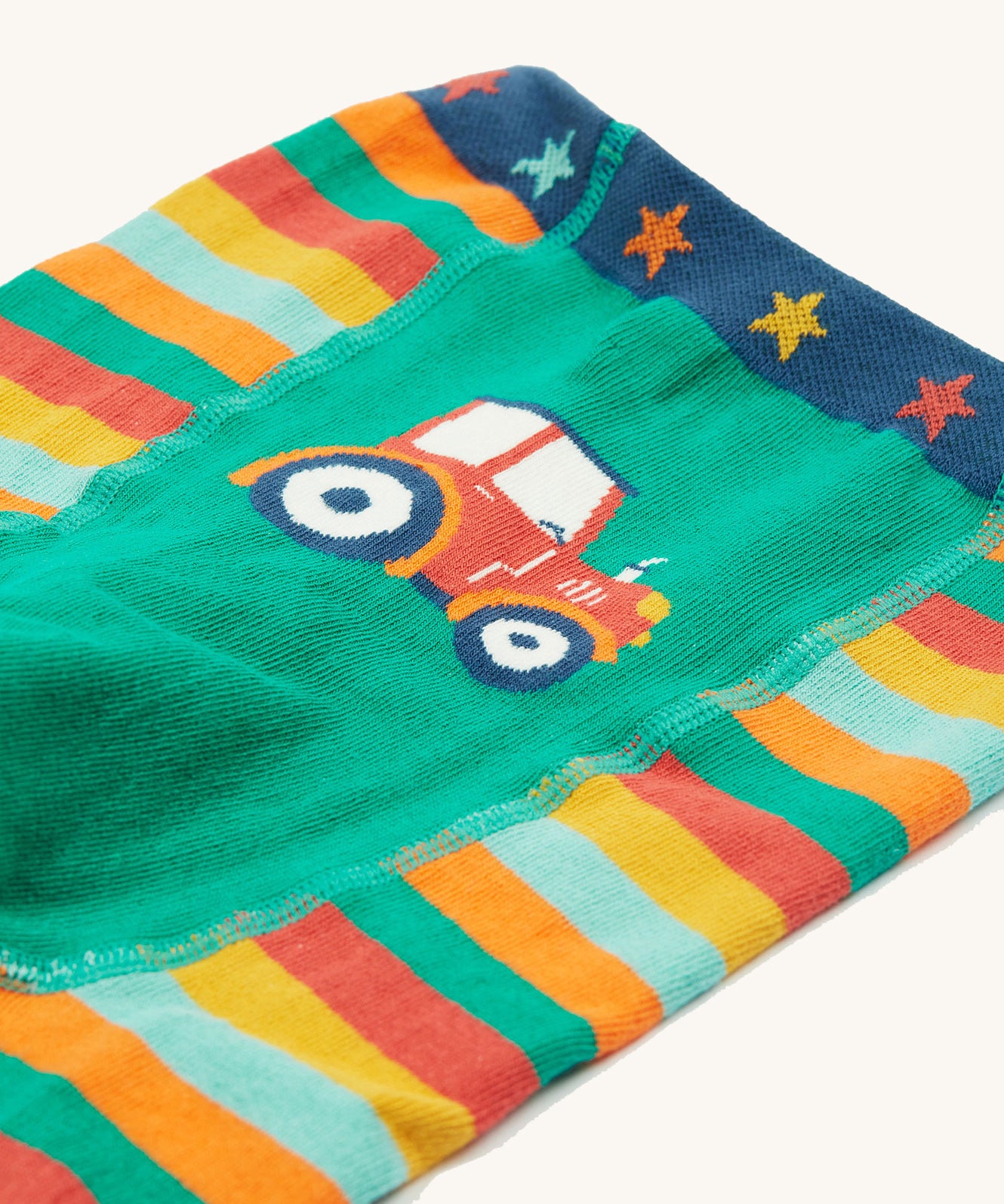 A closer look at the tractor print on the Frugi Little Knitted Leggings - Rainbow Stripe/Tractor