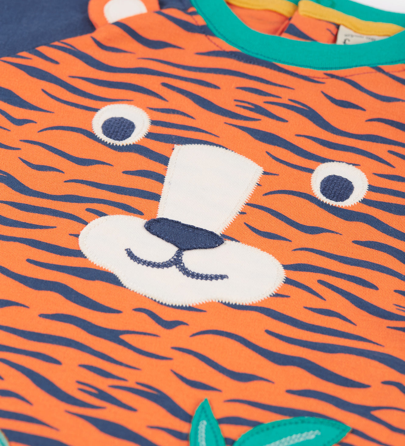 A closer look at the tiger face applique on the Frugi Happy Raglan Top - Tiger