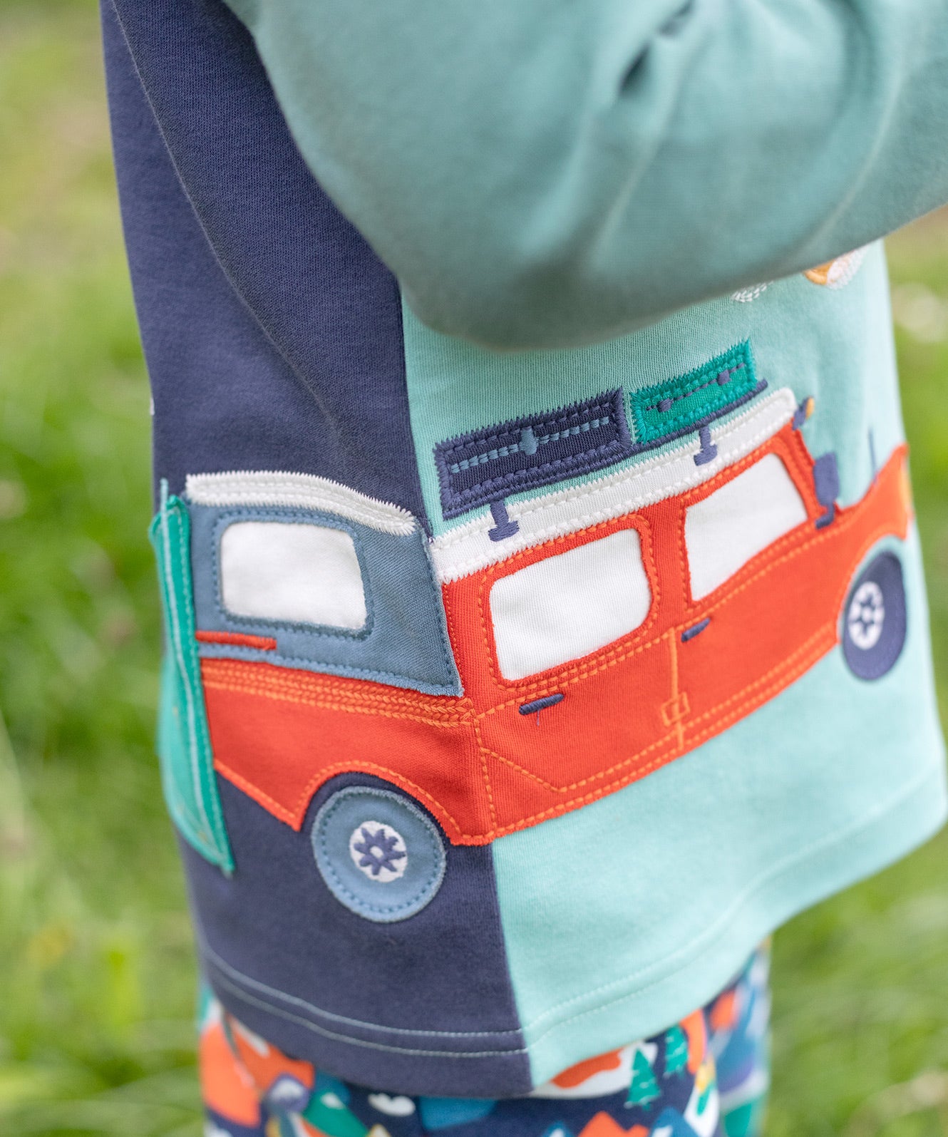 A closer look at the front and back applique on the Frugi Albert Wrap Around Top - Moss/4X4 Camper