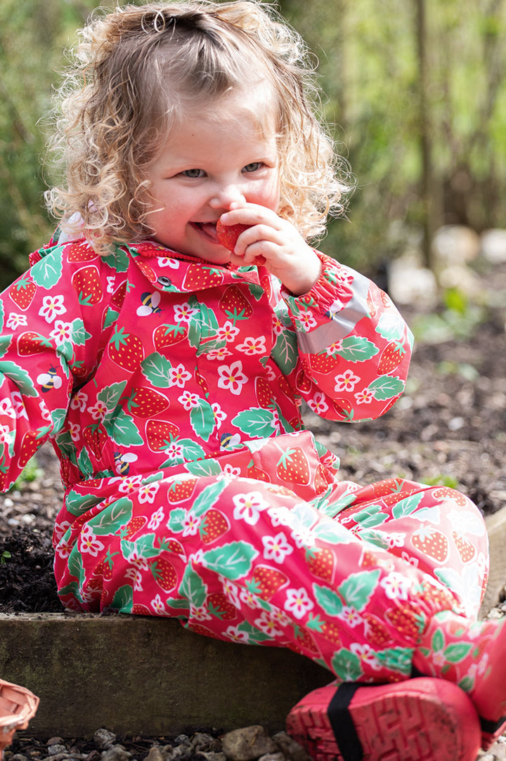 Child wearing Frugi strawberries rain or shine suit to represent Frugi waterproofs at Babipur.