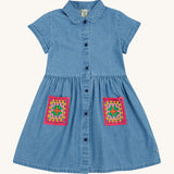 Frugi blue denim dress crochet pocket design on a cream background.