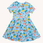 Frugi blue skater dress dinoland design on a cream background.