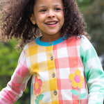 Frugi multicoloured check button cardigan daisy design on a cream background.