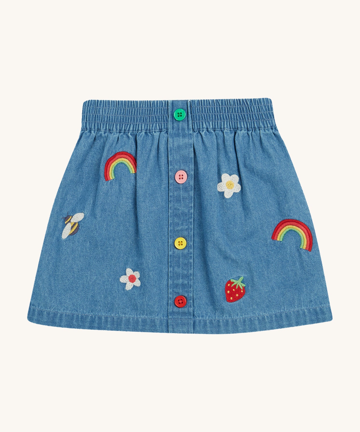 Frugi kids denim skirt with a flower, rainbow and strawberry design on a cream background.