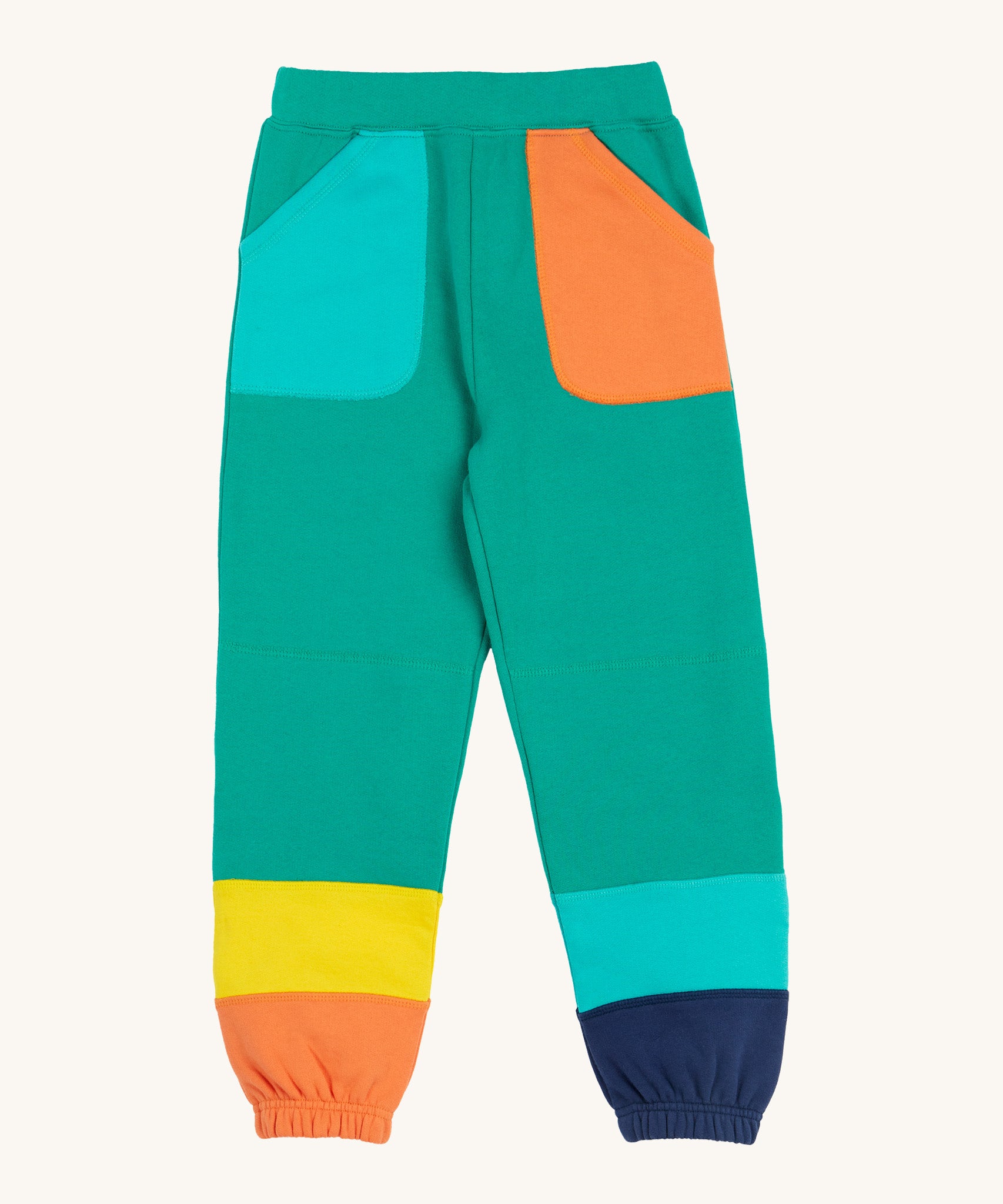 Frugi green joggers with a blue, orange yellow and green colour block design back detail on a cream background.