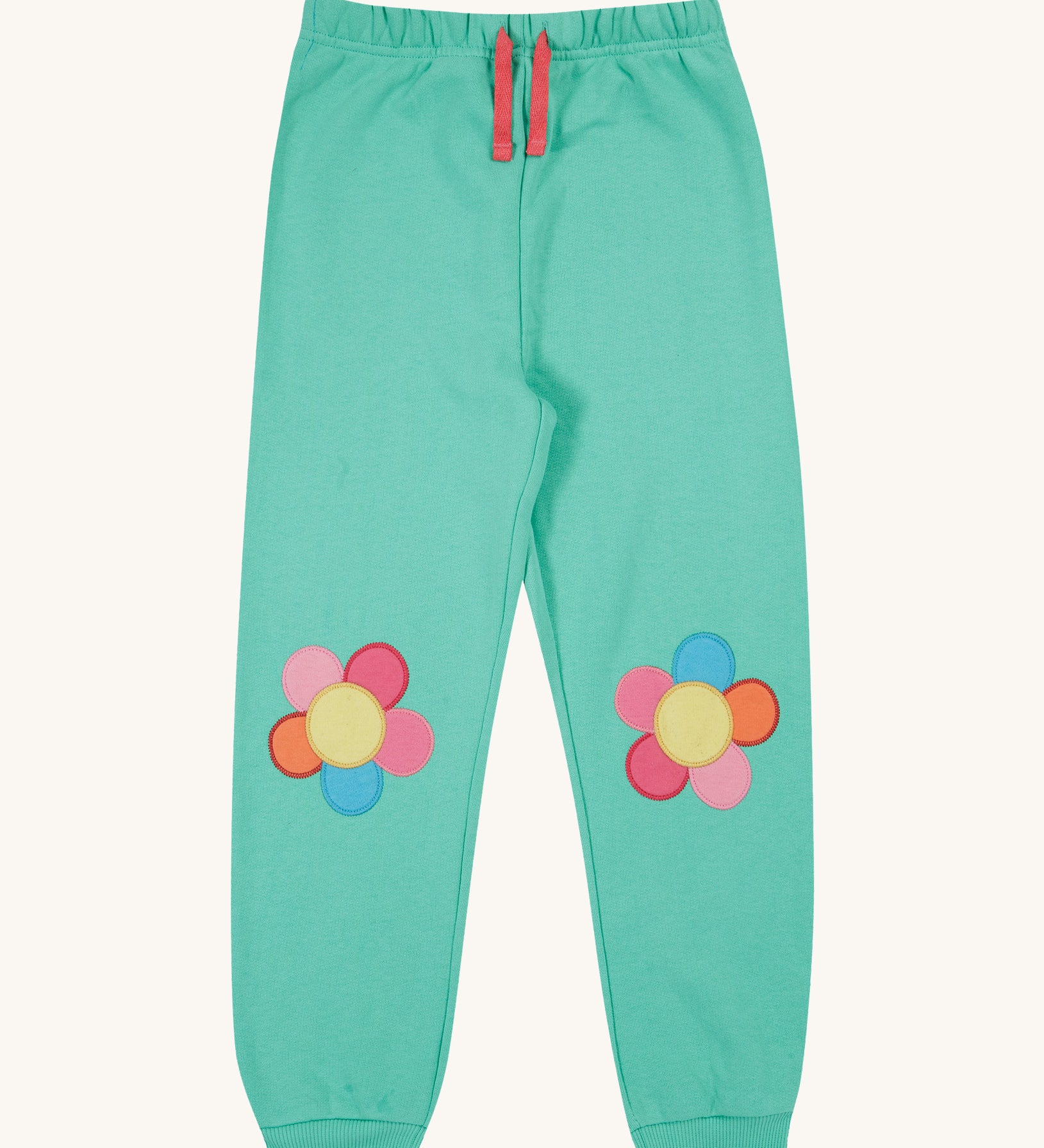 Frugi green crawler joggers daisy design on a cream background.