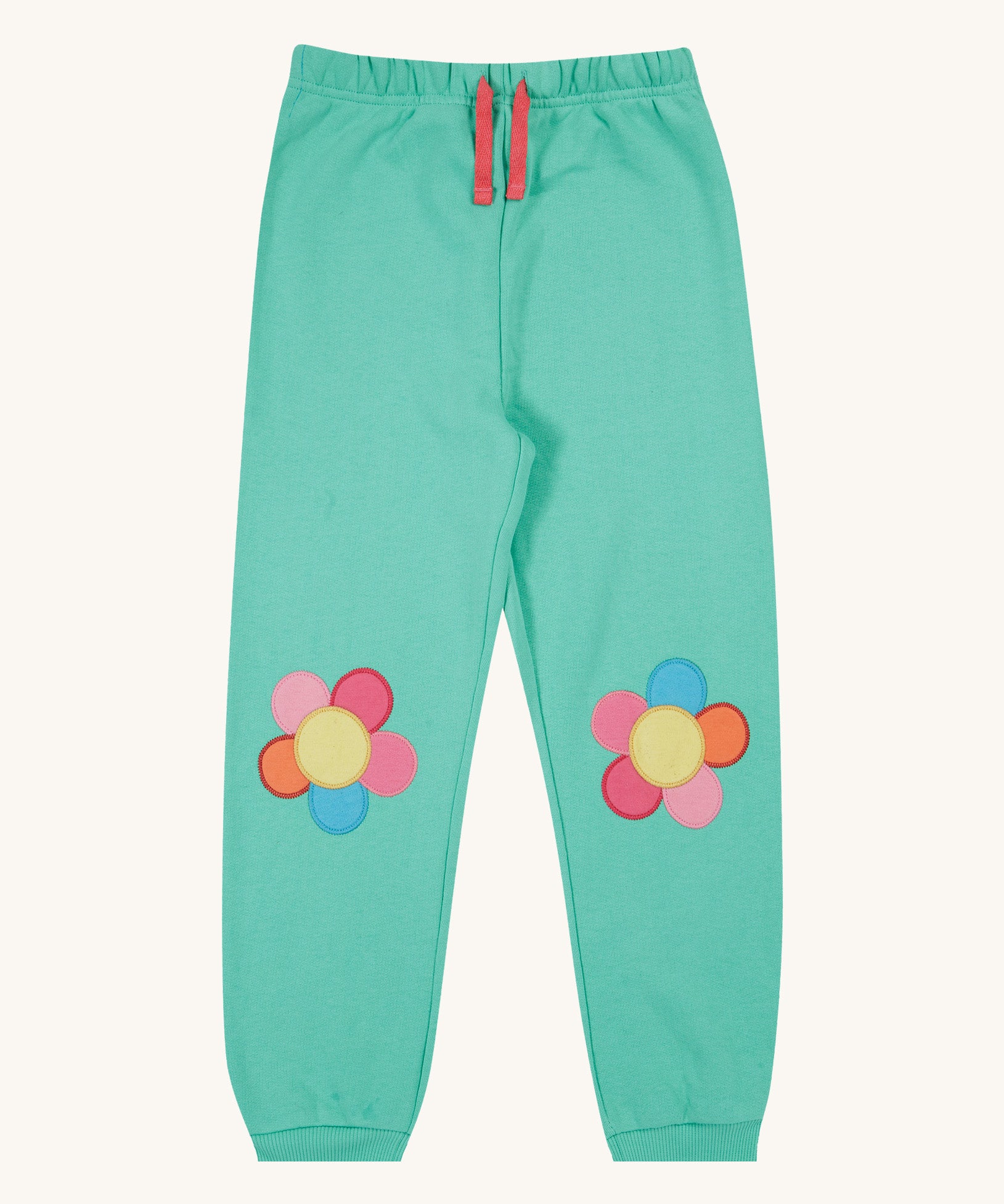 Frugi green crawler joggers daisy design on a cream background.