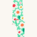 Frugi green leggings daisy design folded on a cream background.