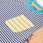 Close up of theFrugi kids hopscotch stripe pocket t-shirt showing the front pocket detail and light blue neck trim on striped organic cotton fabric