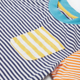 Close up of theFrugi kids hopscotch stripe pocket t-shirt showing the front pocket detail and light blue neck trim on striped organic cotton fabric