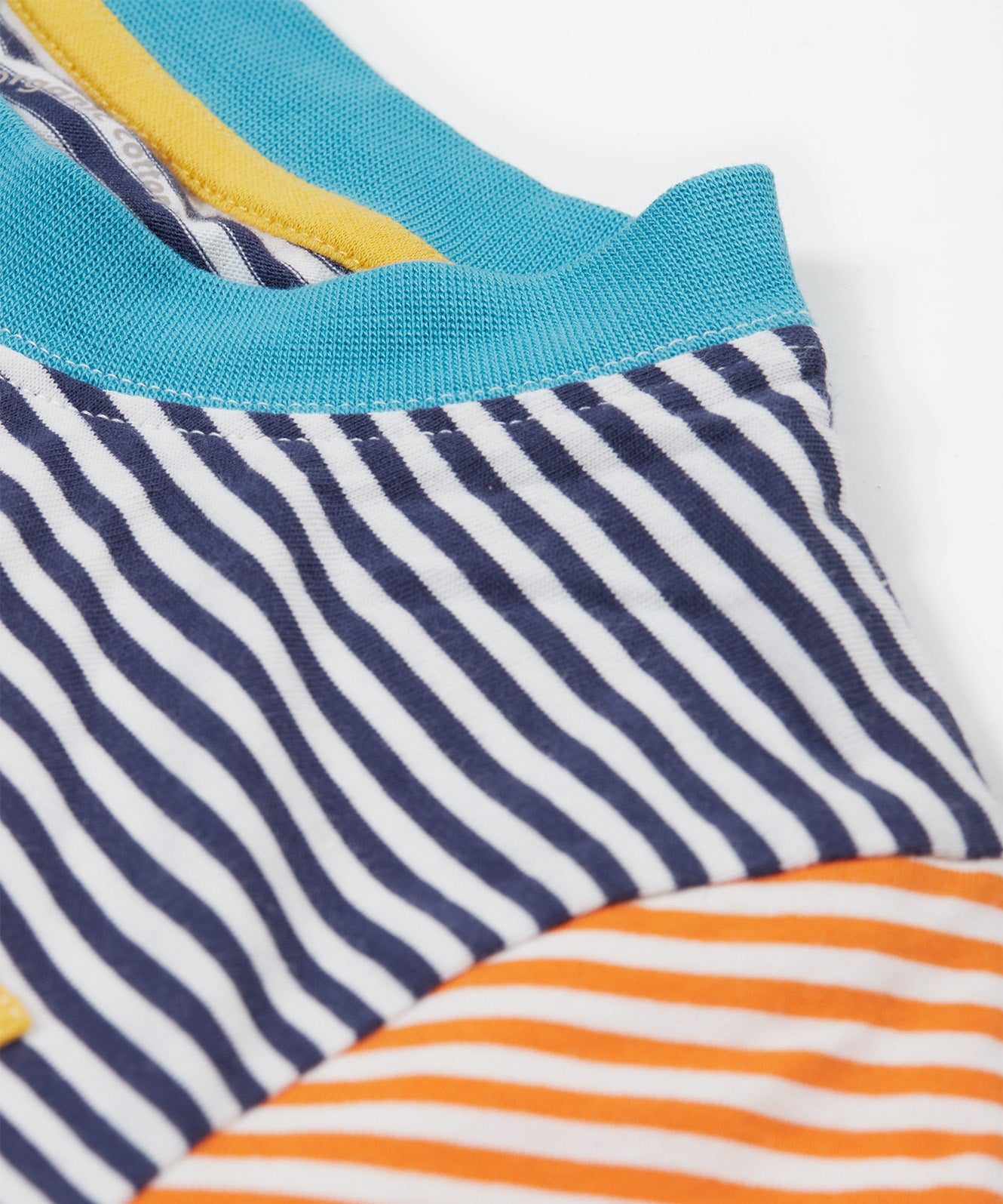 Close up of theFrugi kids hopscotch stripe pocket t-shirt showing the light blue neck trim on striped organic cotton fabric