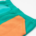 Frugi green joggers with a blue, orange yellow and green colour block design back detail