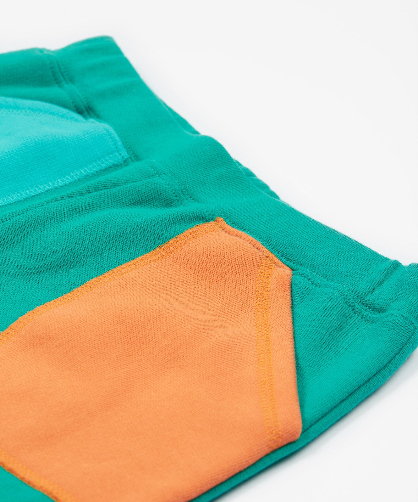 Frugi green joggers with a blue, orange yellow and green colour block design back detail