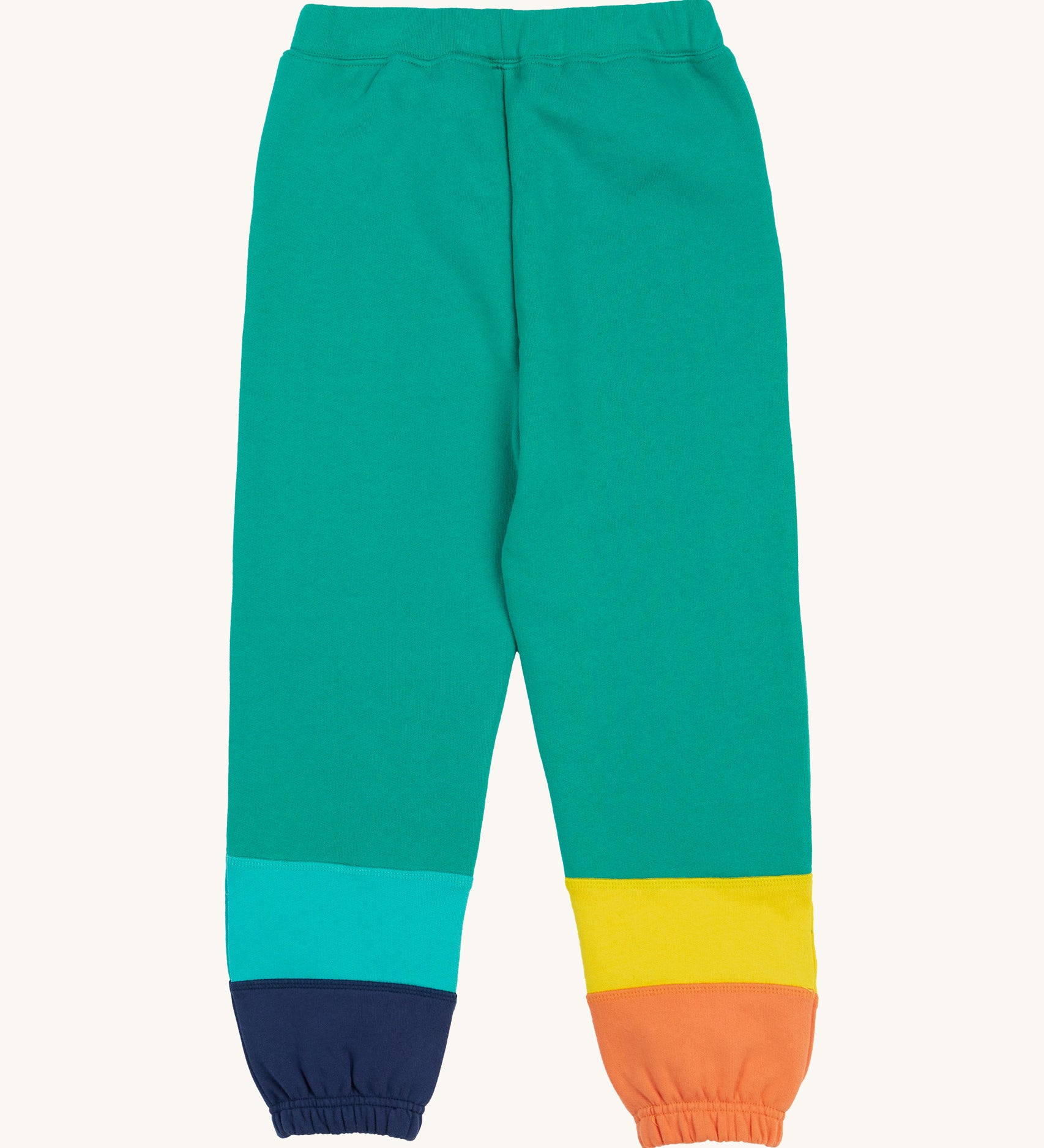 Frugi green joggers with a blue, orange yellow and green colour block design on a cream background.