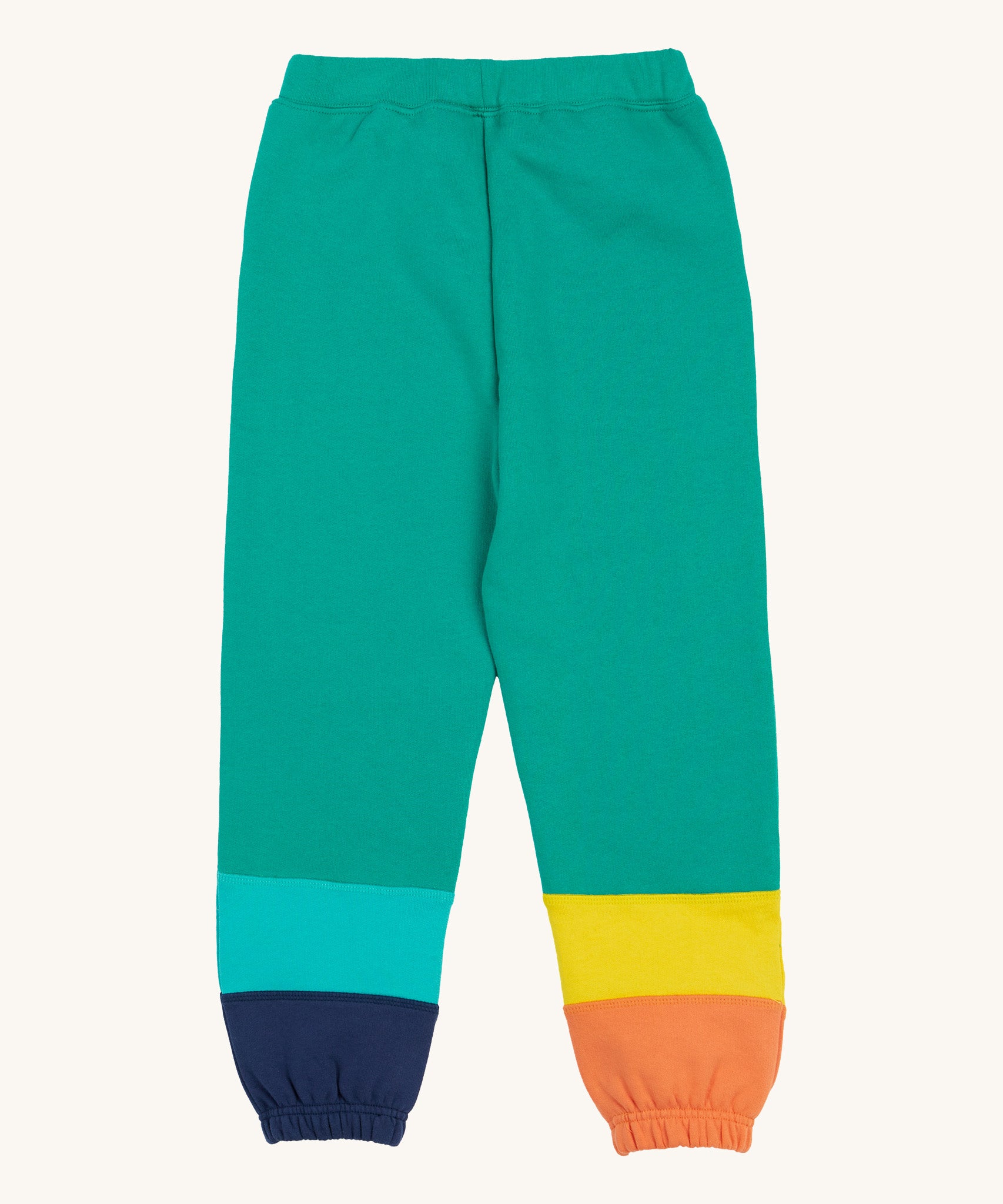 Frugi green joggers with a blue, orange yellow and green colour block design on a cream background.