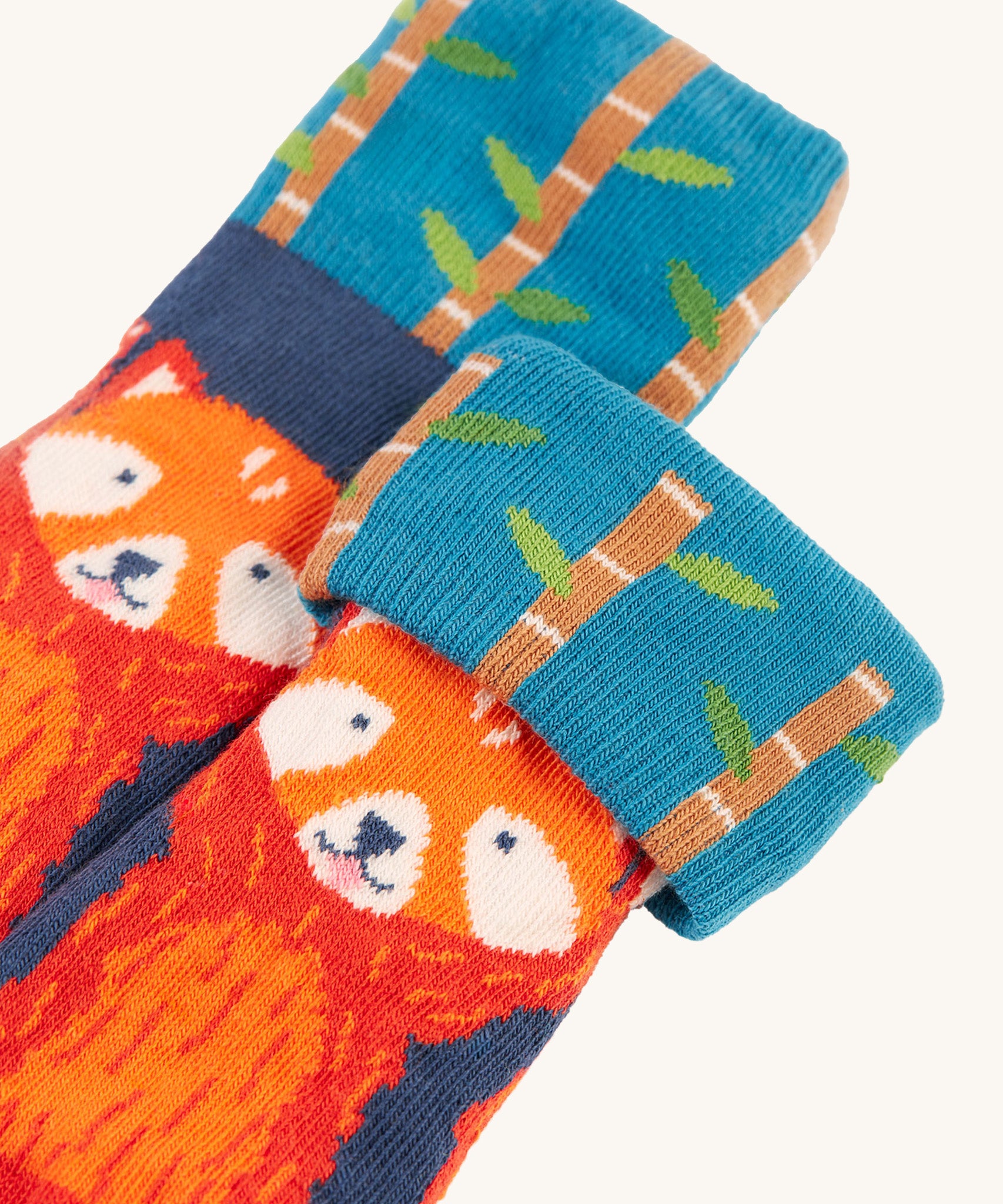 A closer look at the blue, red panda socks from the Frugi Fun Fold Over Socks - Red Panda 2 Pack. A cute red panda print sock, with bamboo stick print fold over tops