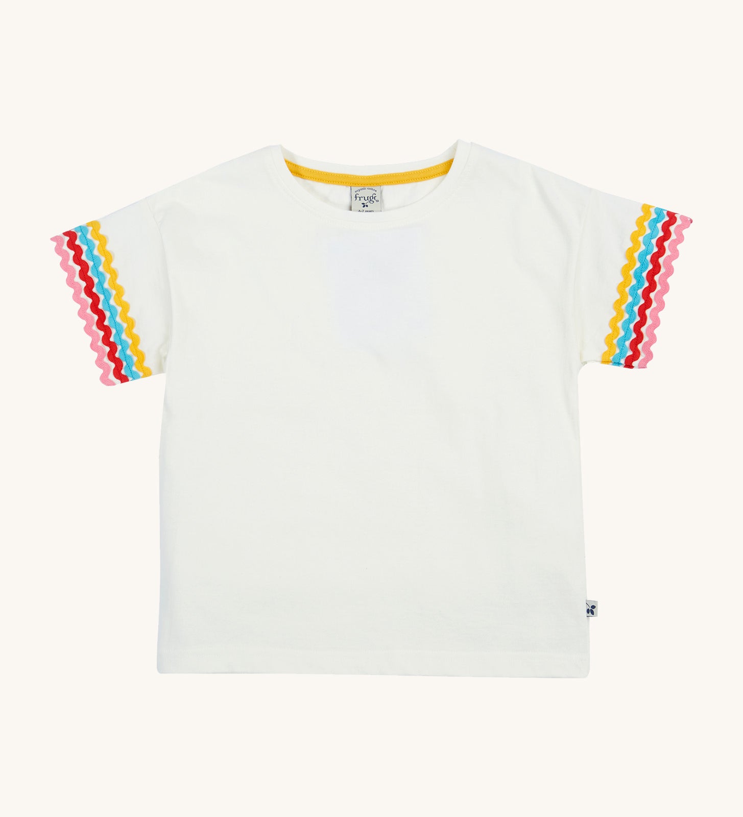 Frugi kids white short sleeve t-shirt with a rainbow trim on the sleeve on a cream background.