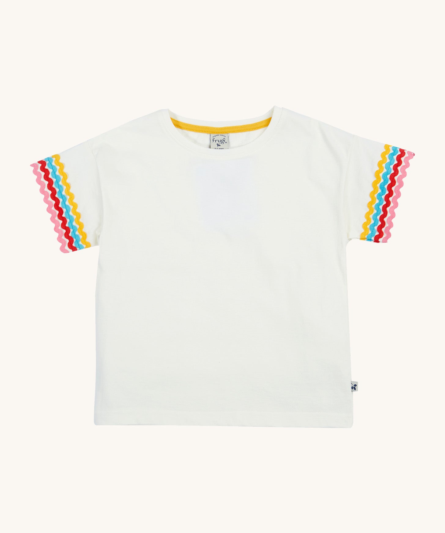 Frugi kids white short sleeve t-shirt with a rainbow trim on the sleeve on a cream background.