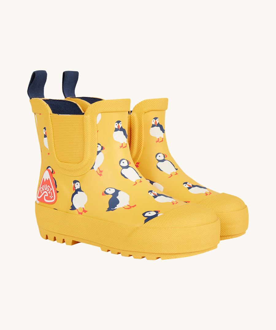 Frugi kids yellow wellington boots puffin design on a cream background.