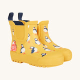 Frugi kids yellow wellington boots puffin design on a cream background.