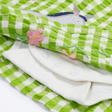 Close up of the Frugi little kids green gingham, donkey myrtle body dress - showing a grey donkey appliqué and a white underneath body garment underneath on green and white gingham organic cotton fabric