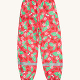 Frugi pink rain shine trousers strawberries design on a cream background.