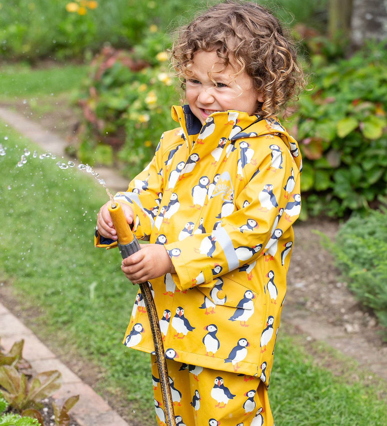 Frugi kids puddle buster jacket yellow with a puffin design 