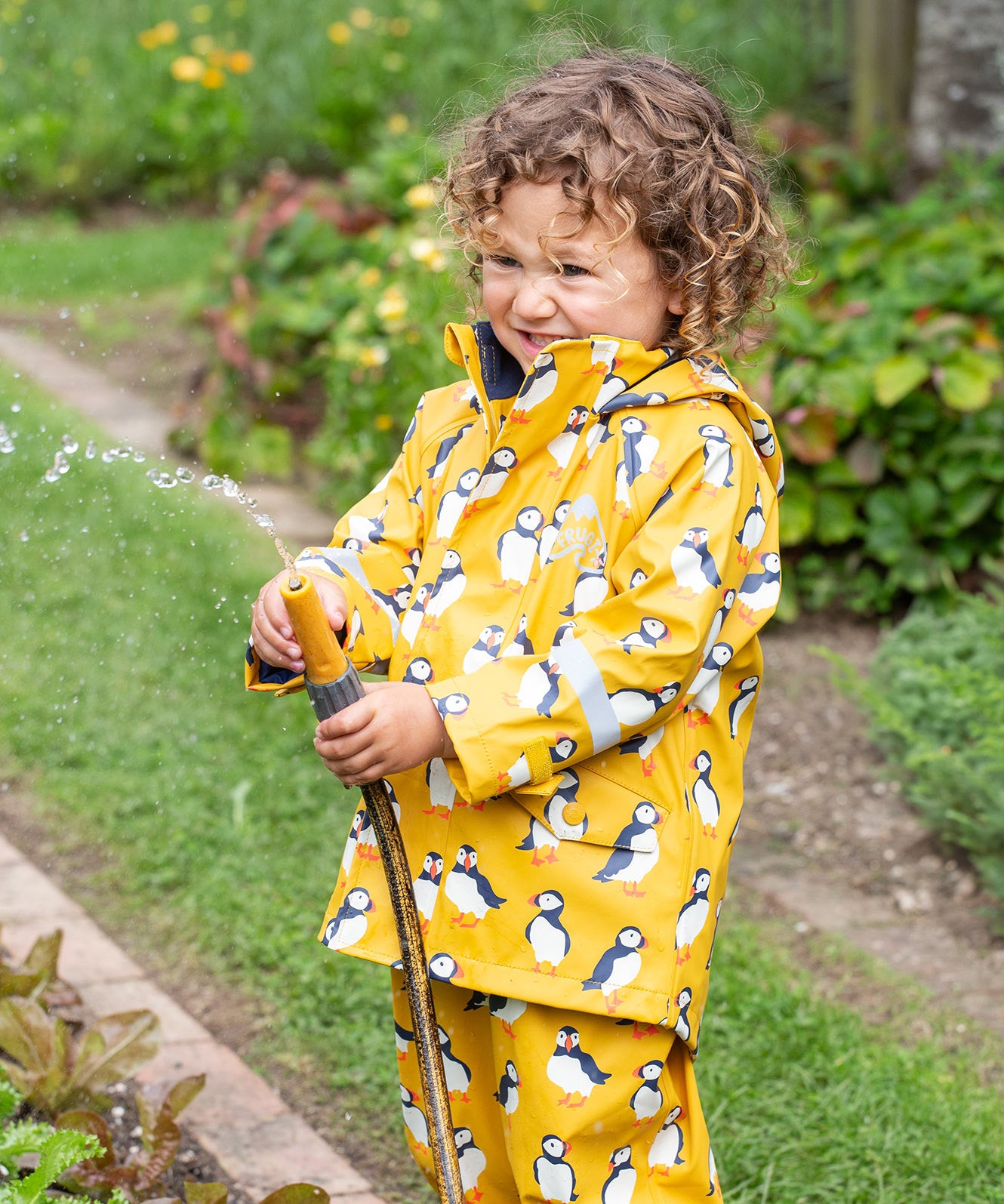 Frugi kids puddle buster jacket yellow with a puffin design 