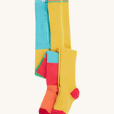 Frugi 2 pack ribbed tights in a rainbow colour block design on a cream background.