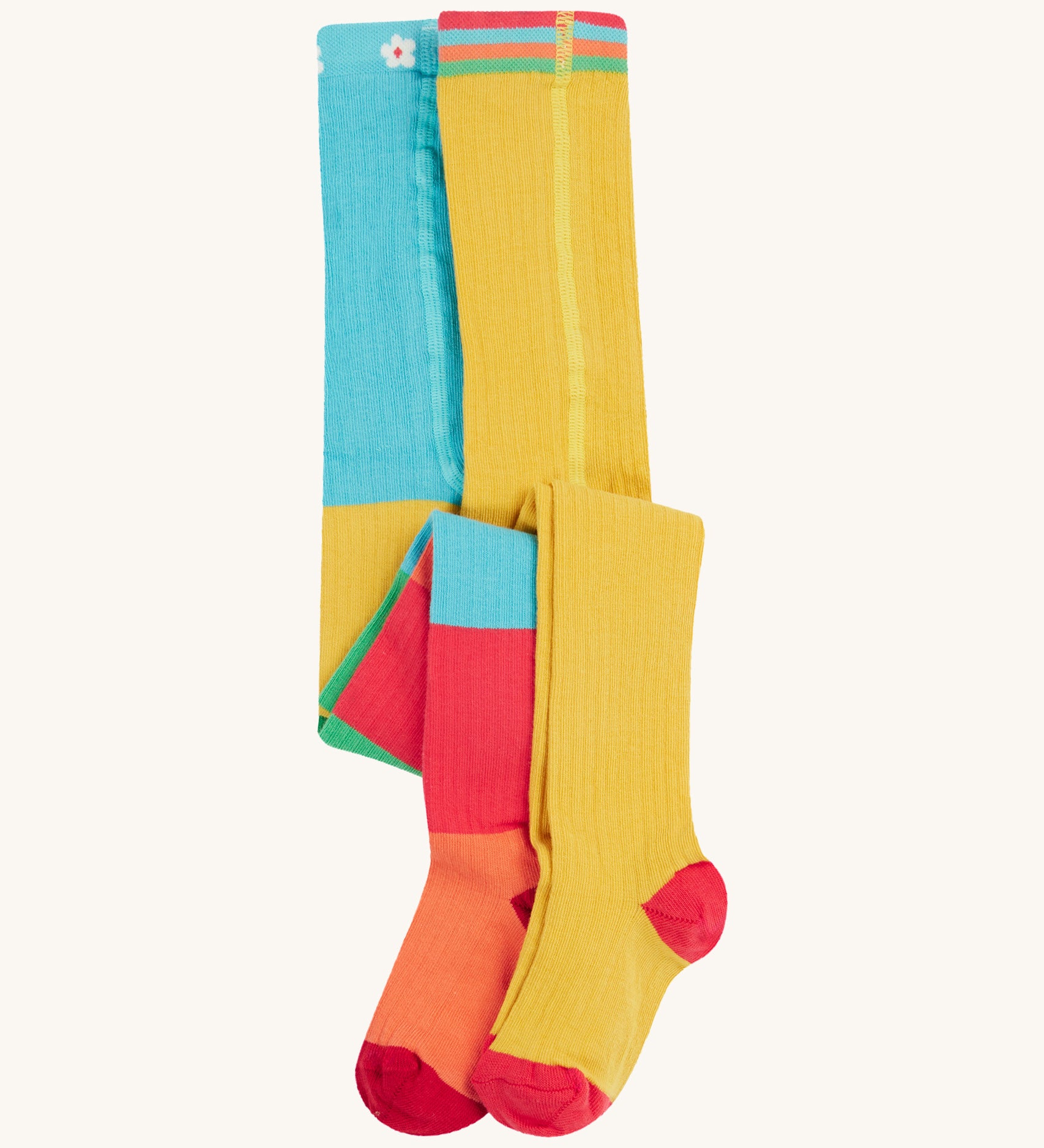 Frugi 2 pack ribbed tights in a rainbow colour block design on a cream background.