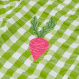 Close up of the Frugi Reggie kids shirt. showing the beetroot embroidery detail on green gingham organic cotton fabric