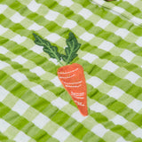 Close up of the Frugi Reggie kids shirt. showing the carrot embroidery on  green gingham organic cotton fabric