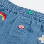 Frugi kids denim skirt with a flower, rainbow and strawberry design button detail