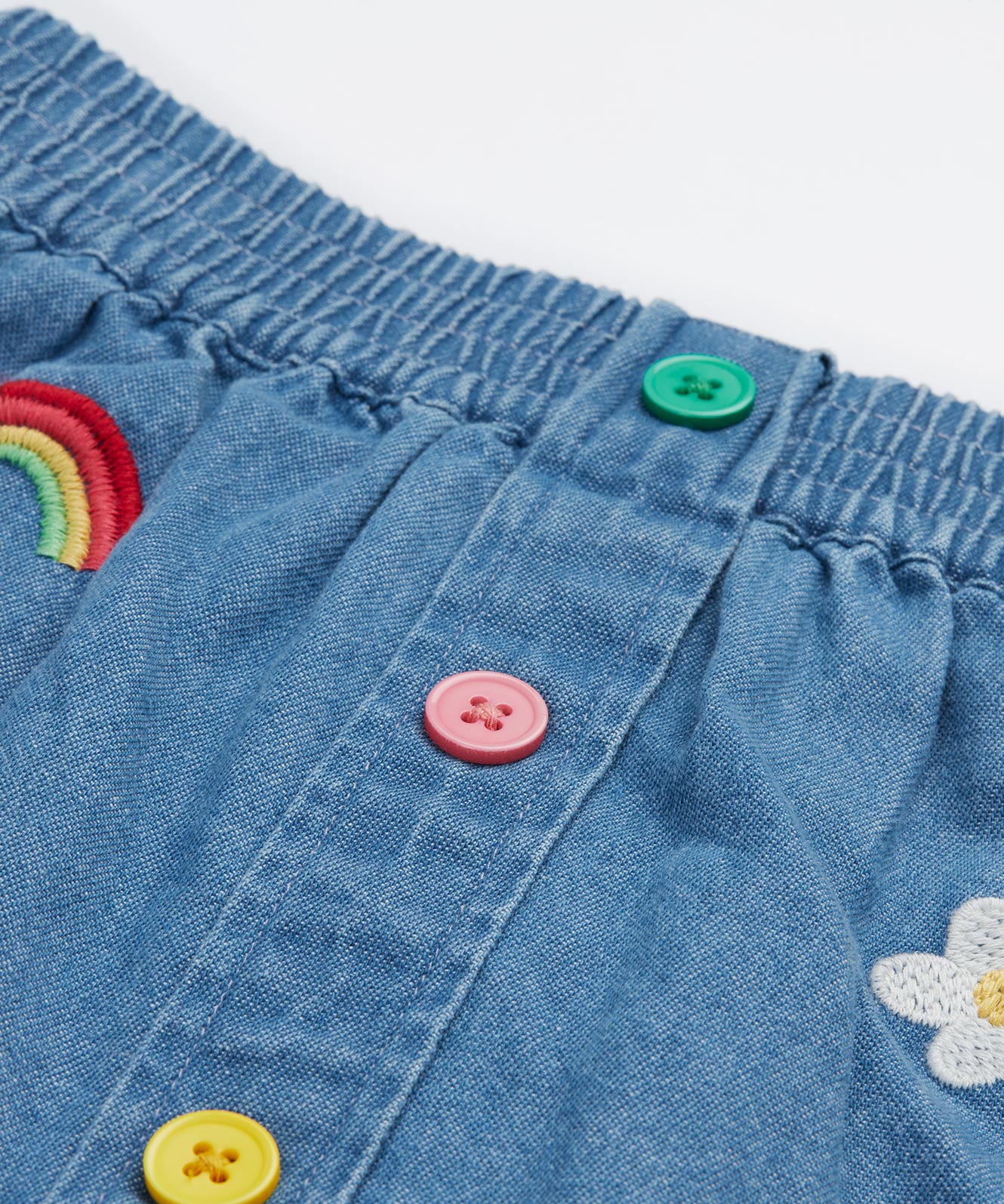 Frugi kids denim skirt with a flower, rainbow and strawberry design button detail