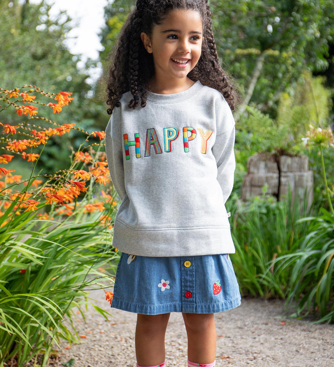 Frugi kids denim skirt with a flower, rainbow and strawberry design