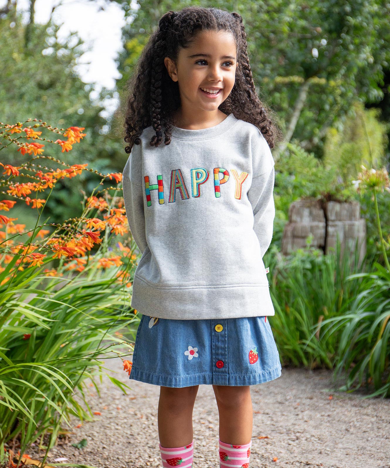 Frugi kids denim skirt with a flower, rainbow and strawberry design