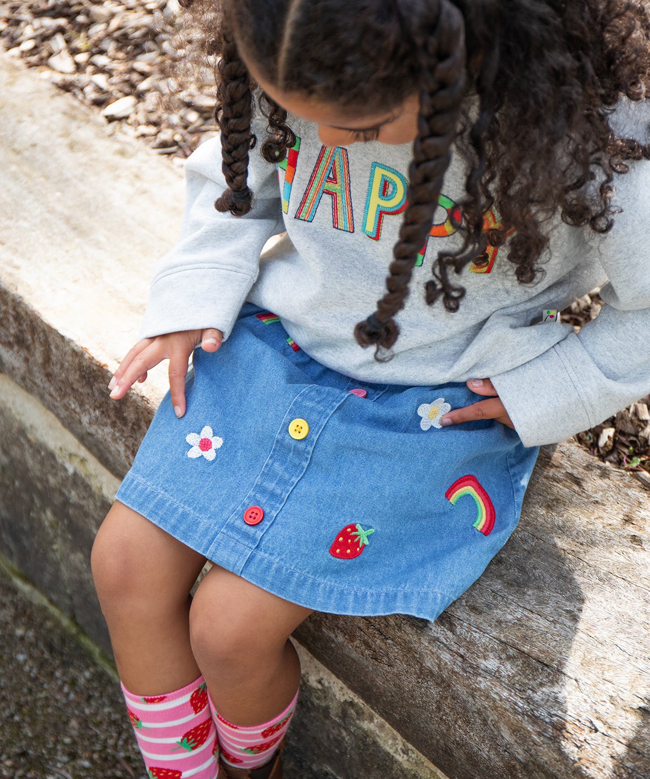 Frugi kids denim skirt with a flower, rainbow and strawberry design detail