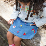 Frugi kids denim skirt with a flower, rainbow and strawberry design detail