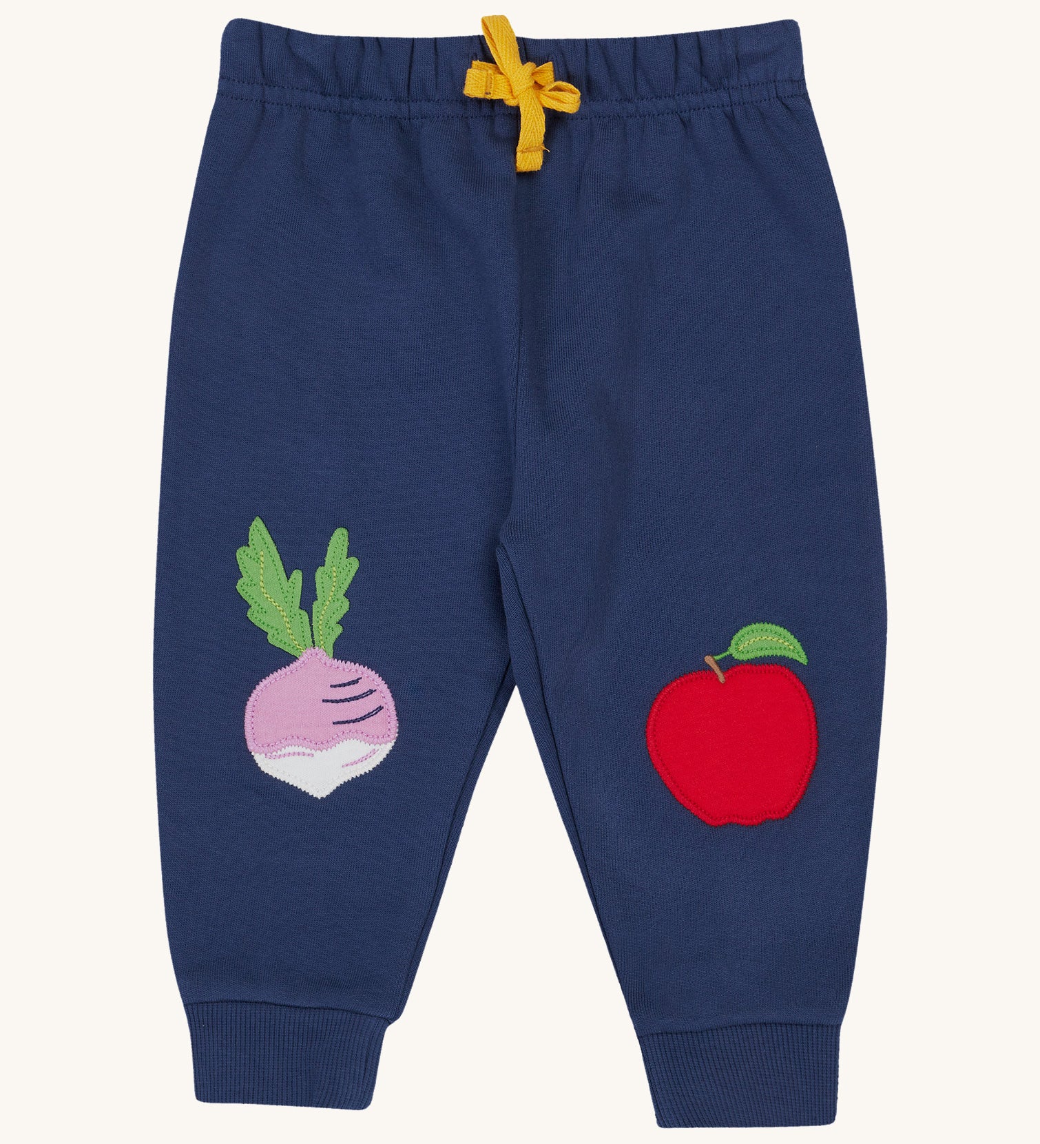 Frugi navy crawler joggers veg design on a cream background.