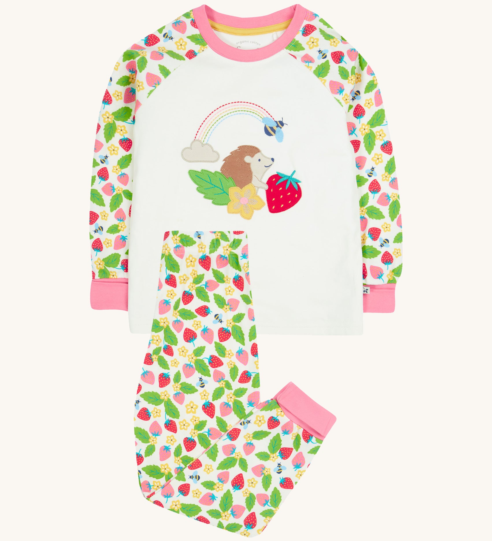 Frugi white pyjama set strawberry field design on a cream background.