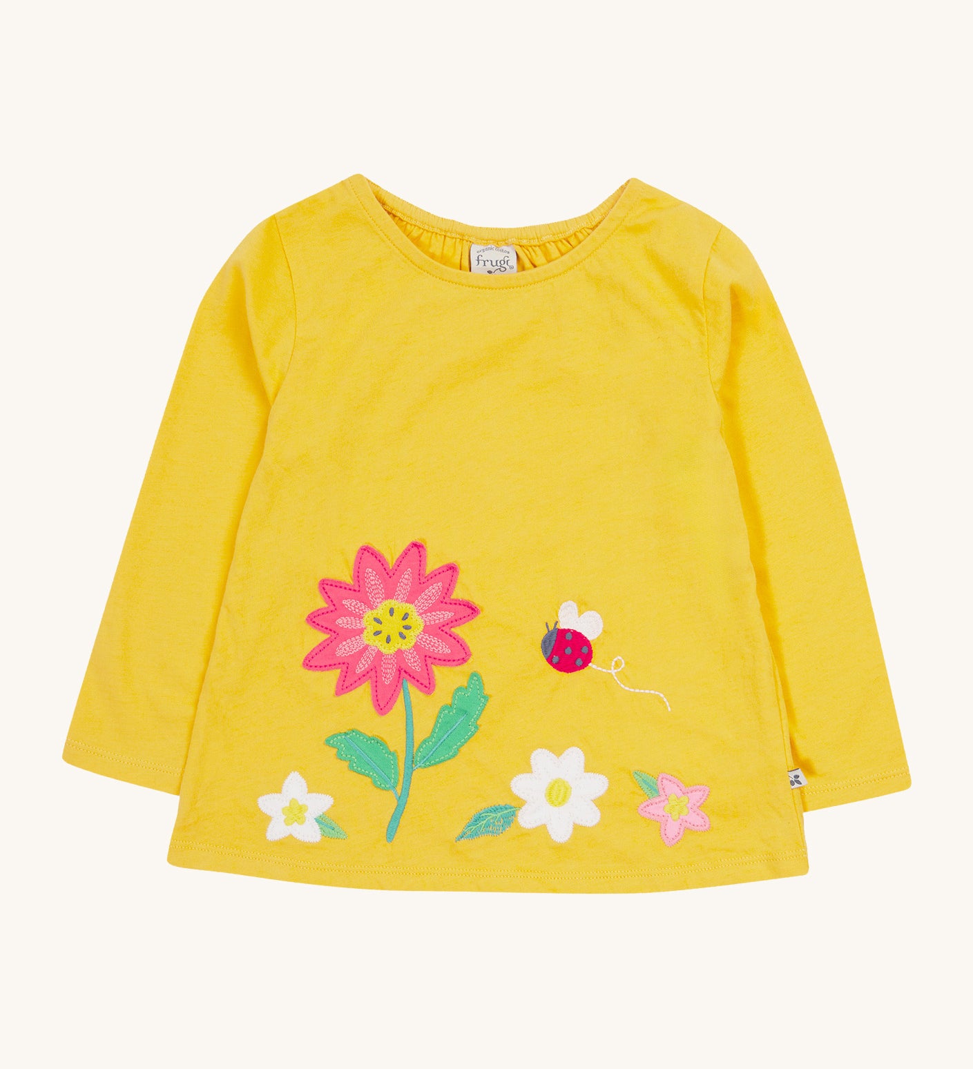 Frugi yellow long sleeve top flowers design on a cream background.