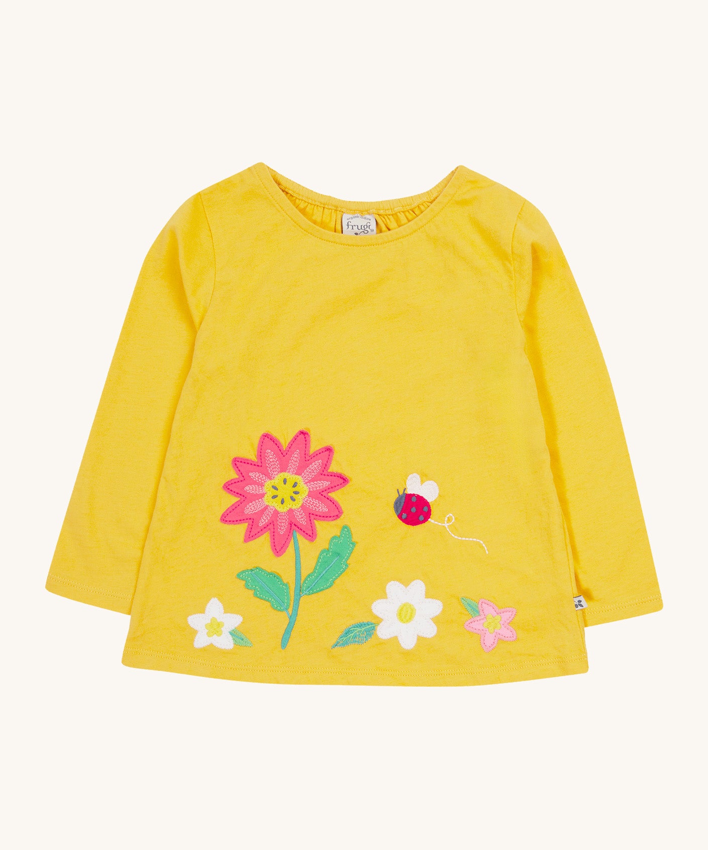 Frugi yellow long sleeve top flowers design on a cream background.