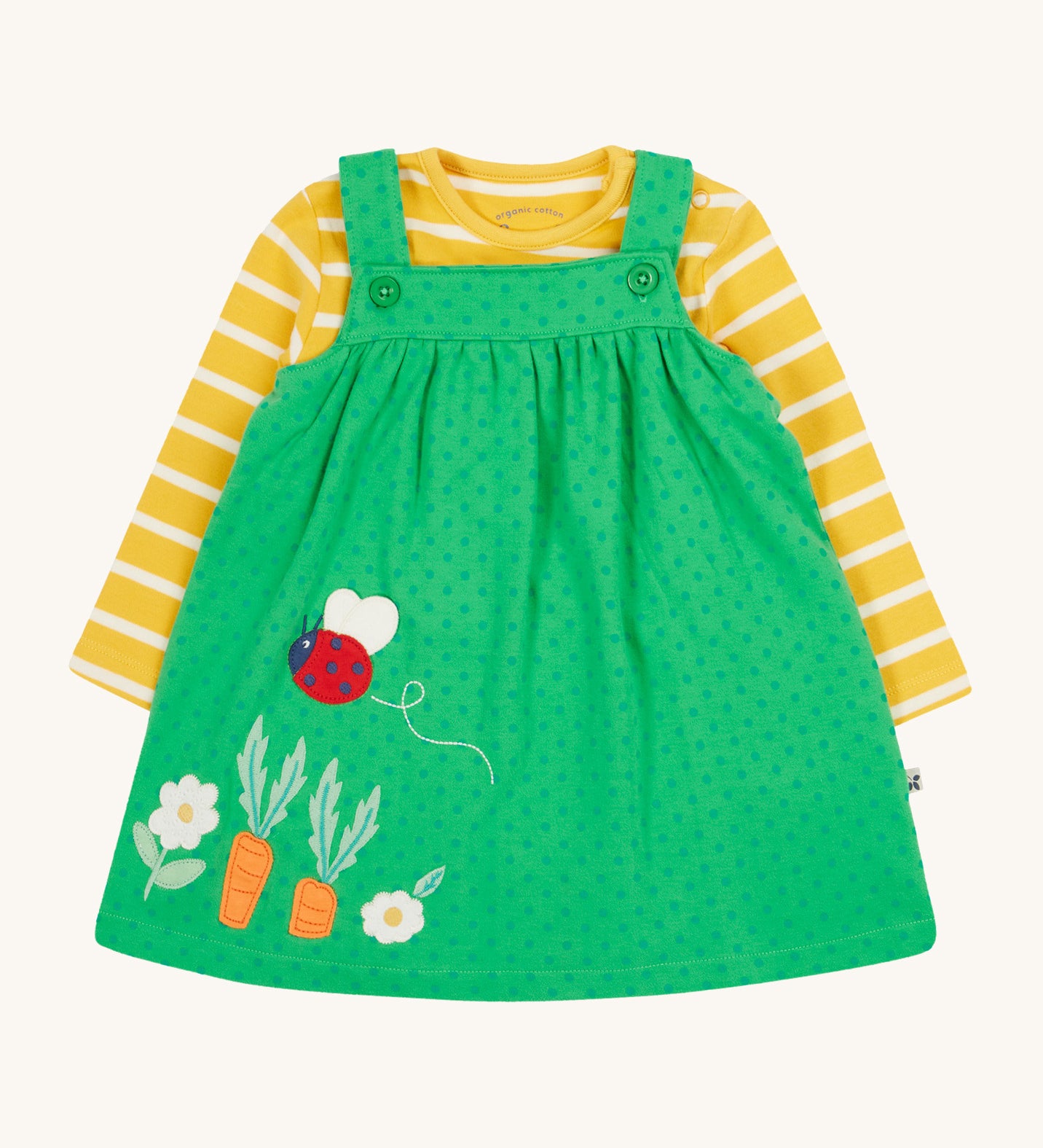 Frugi yellow stripe green spots pinafore outfit lady bird design on a cream background.