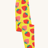 Frugi yellow leggings strawberry patch design folded on a cream background