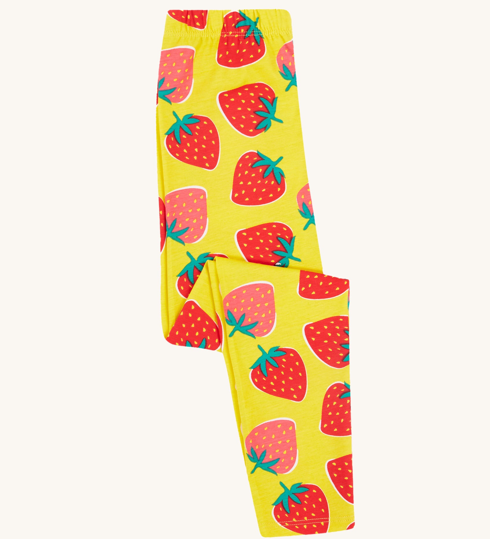 Frugi yellow leggings strawberry patch design folded on a cream background