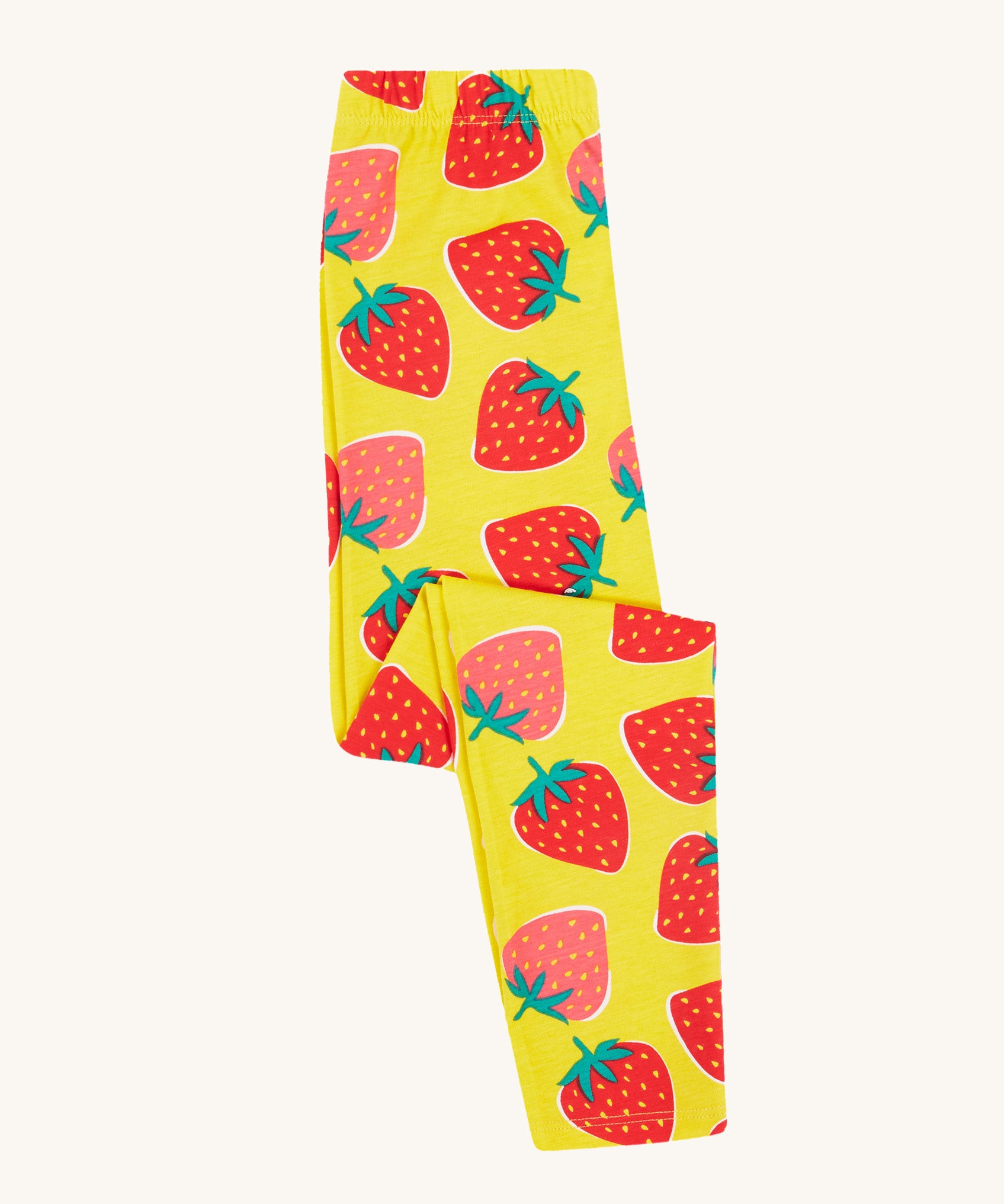 Frugi yellow leggings strawberry patch design folded on a cream background