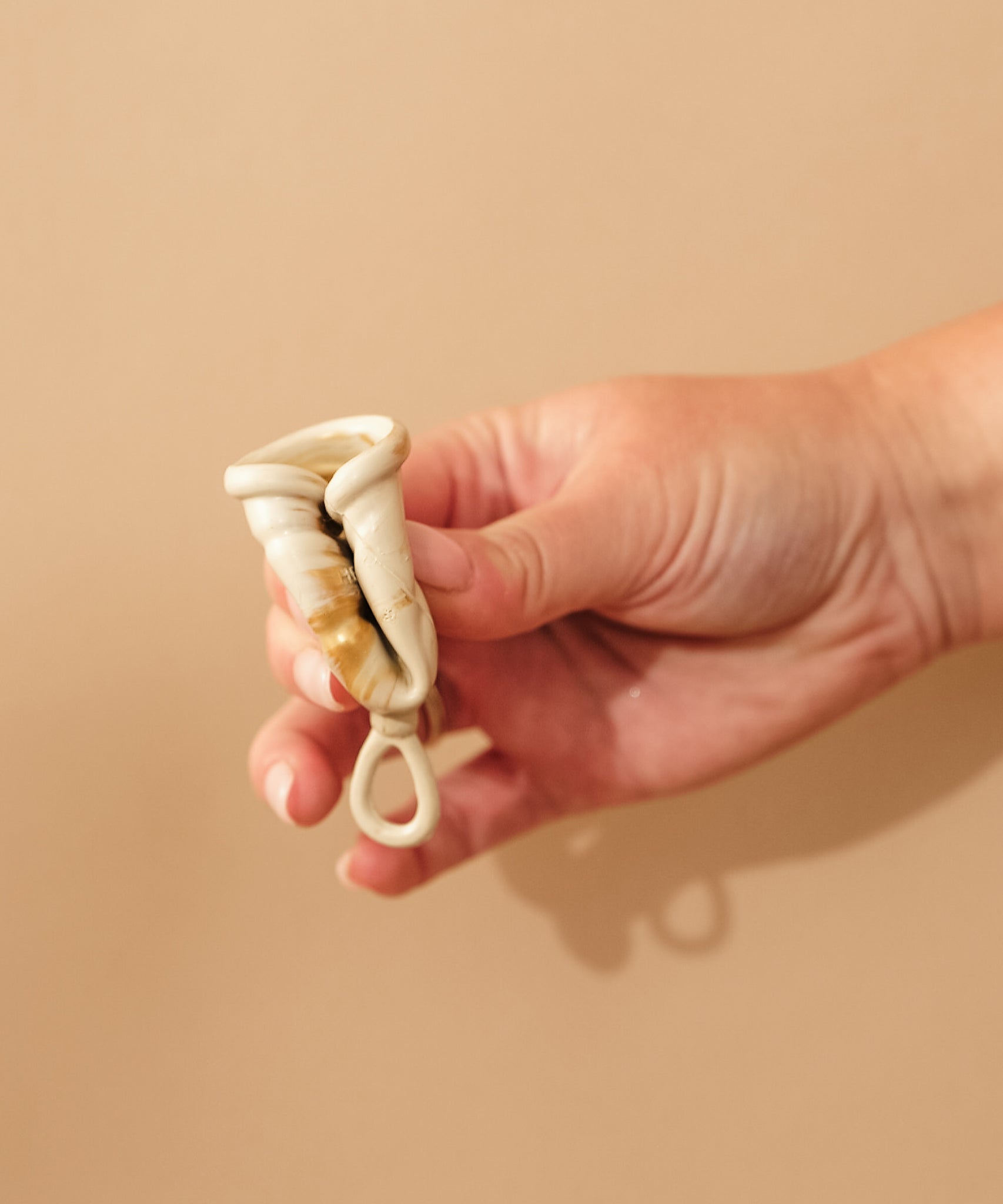 Person demonstrating how to fold a HEVEA LOOP menstrual cup.