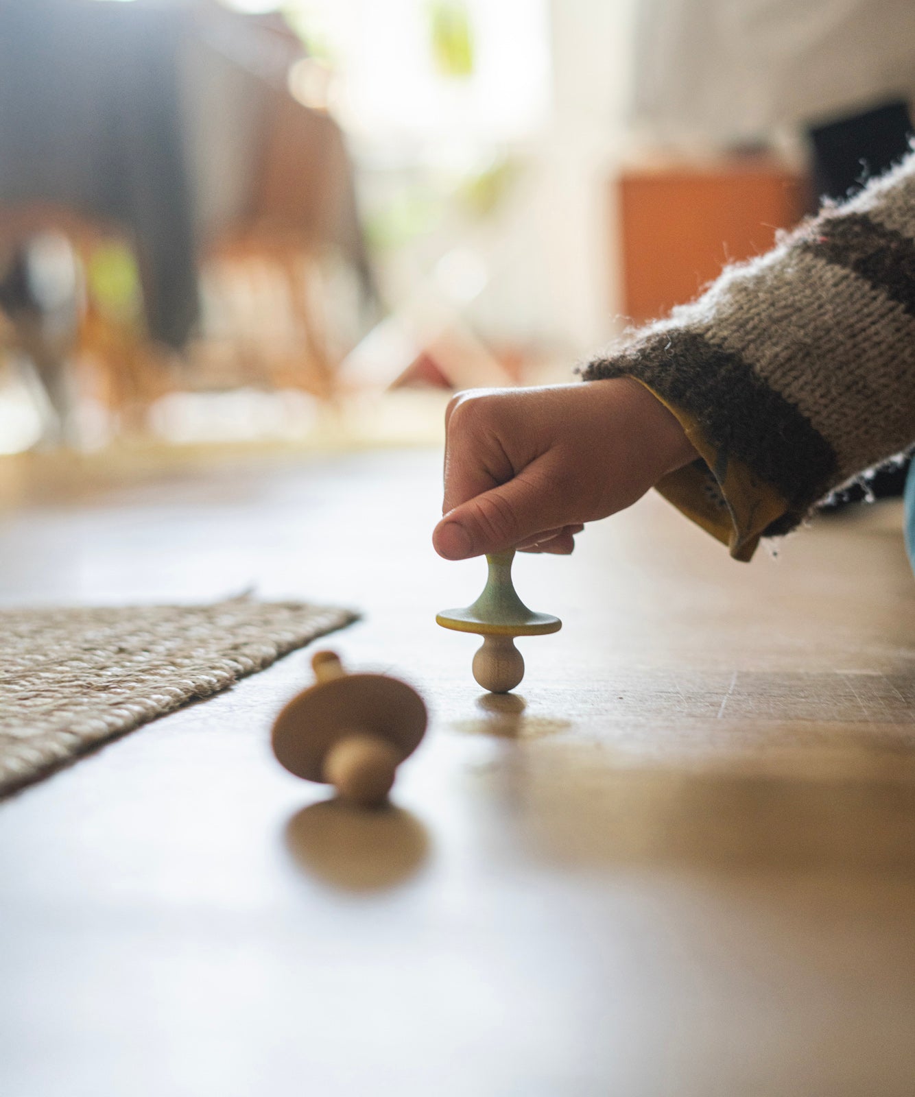 A child is playing with the wooden spinning tops from the Grapat Advent Calendar 2024